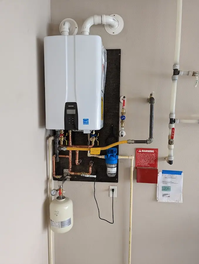 Professional plumber installing copper piping in a Newport home